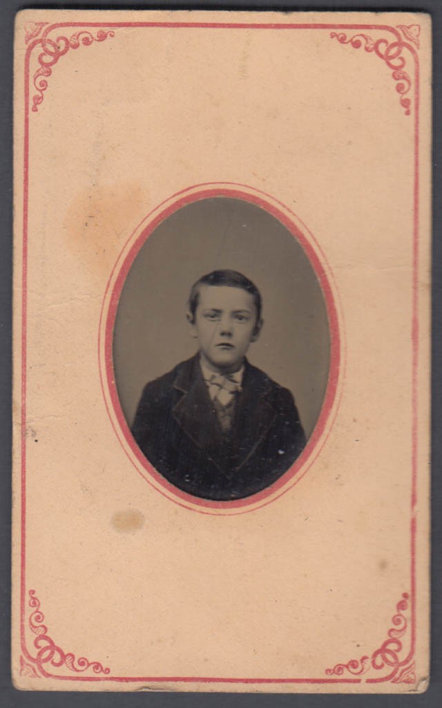 Young boy in suit tintype in oval paper matte ca 1860s